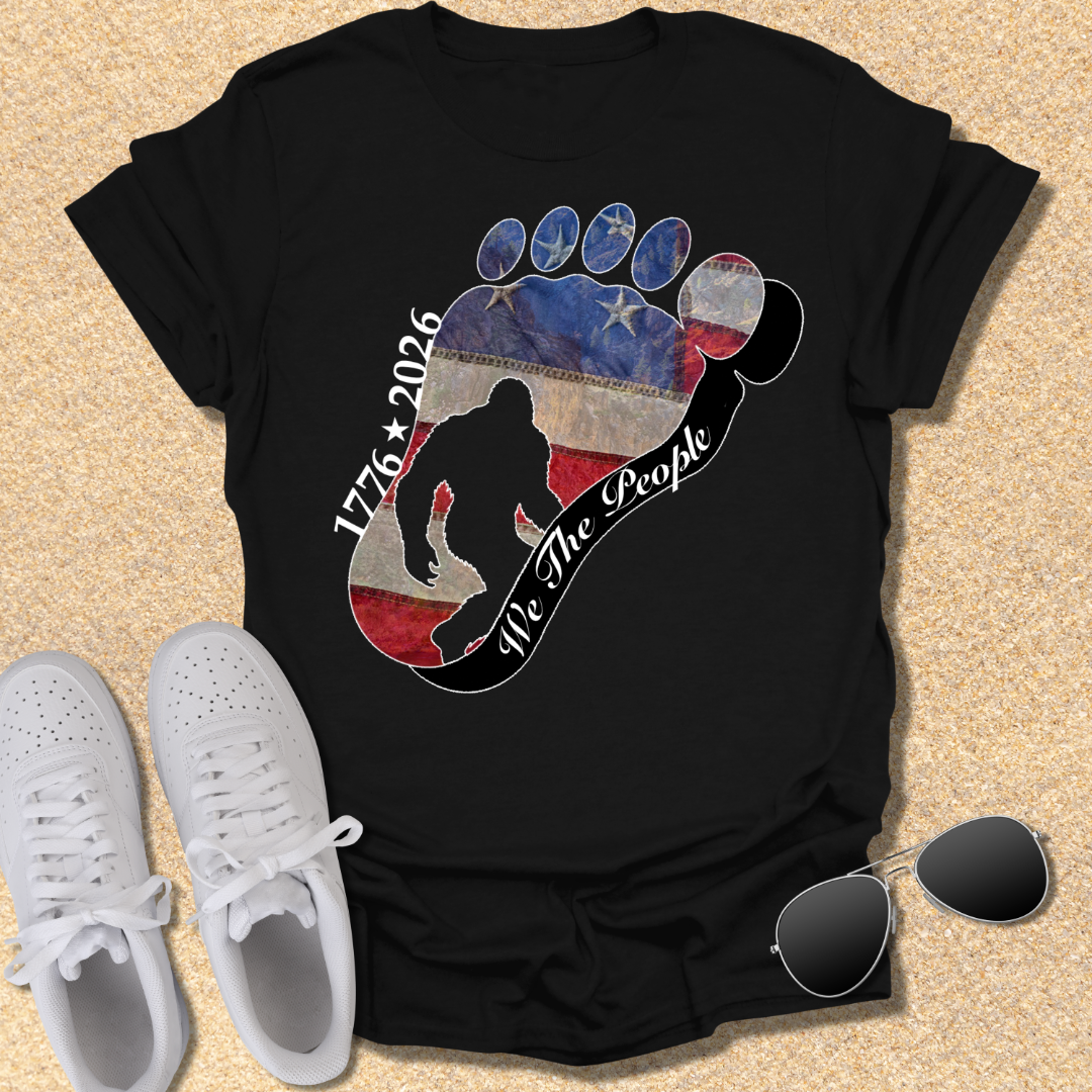 Going Norther Bigfoot T-Shirt — Footprint Silhouette with Distressed Flag & "1776 - 2026 - We The People"