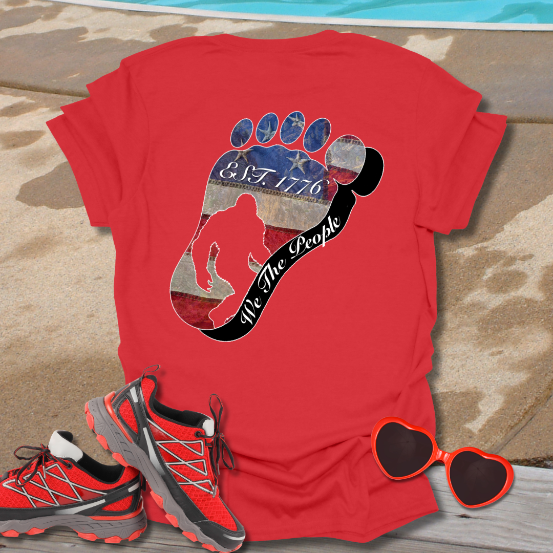 Going Norther Bigfoot T-Shirt — Footprint Silhouette with Distressed Flag "EST. 1776 - We The People"