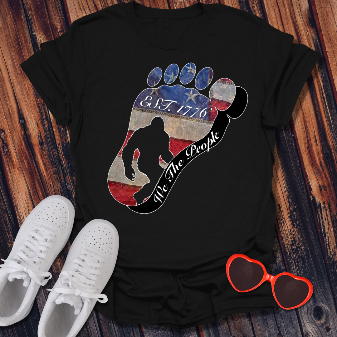 Going Norther Bigfoot T-Shirt — Footprint Silhouette with Distressed Flag "EST. 1776 - We The People"