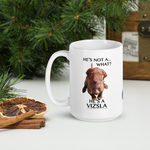 He's not a what? He's a Vizsla 15oz. white ceramic mug on desk